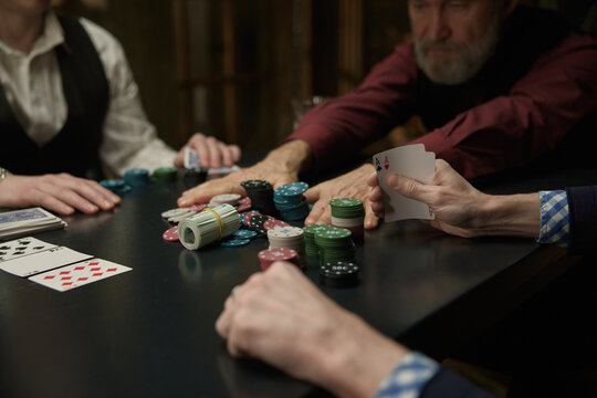 Men enjoying poker game with colorful chips and cards together - Powered by Adobe