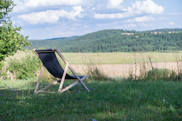 camping chair on grass field and hills in background