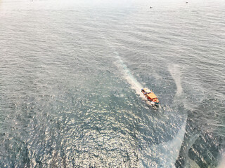Boat navigating through sparkling blue waters under clear skies in a coastal region
