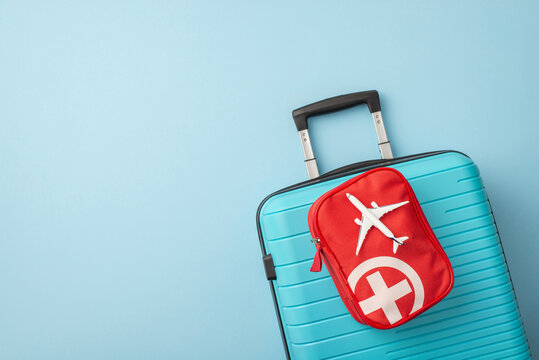 Blue travel suitcase with a red bag containing travel essentials, symbolizing safe travel. Essentials include medical and airplane motifs, enhancing the concept of preparedness for any trip