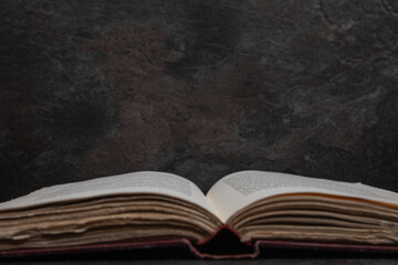 Symmetrical view of open antique book focused on text, bottom edge
