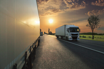 Large Transportation Truck on a highway road through the countryside at sunset

