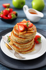 pancakes topped with apple slices and strawberries