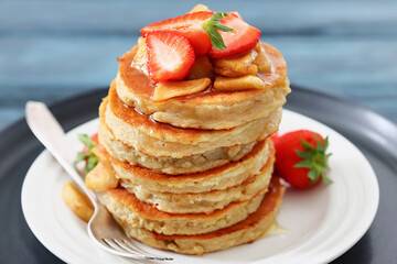 pancakes topped with apple slices and strawberries