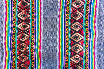 Colorful hand-woven Inca textile background with ancient designs from the Andes mountain range of...
