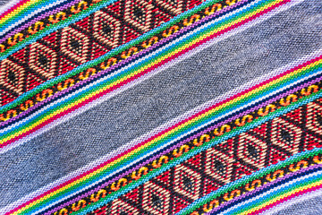 Colorful hand-woven Inca textile background with ancient designs from the Andes mountain range of...