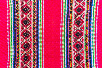Colorful hand-woven Inca textile background with ancient designs from the Andes mountain range of...