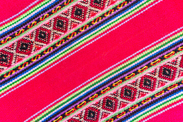 Colorful hand-woven Inca textile background with ancient designs from the Andes mountain range of...