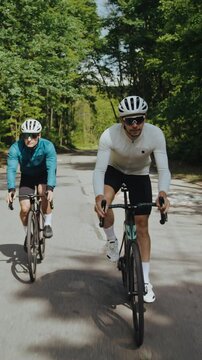 Skilled cyclists in hard hats and glasses compete riding vehicles