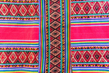 Colorful hand-woven Inca textile background with ancient designs from the Andes mountain range of...