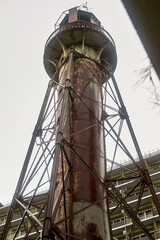 Old rusty lighthouse against the grey sky