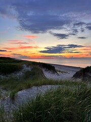 warm sunset over the sand dunes covered in lush beach grass