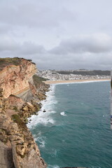 View from the cliffs of Nazar&eacute;, Portugal, overlooking Praia da Nazar&eacute; and the town's white houses nestled by the Atlantic coast