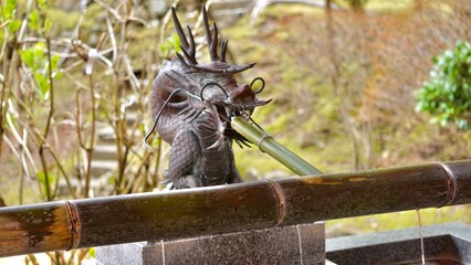 Metal dragons at a purification pavilion chozu-ya Japanese temple  