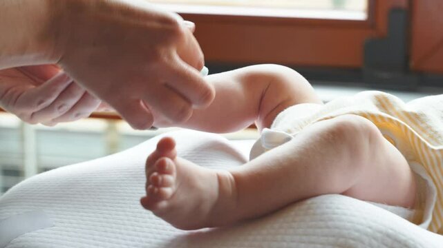 Parent fasten a smart monitor sock on baby foot to track health and prevent sudden infant death, baby health, newborn safety