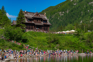 People resting around Morskie Oko, the largest lake in the Tatra Mountains in Zakopane, Poland © momo11353