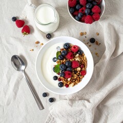 Overhead View White Bowl of Yogurt with Granola and Berries on Beige Fabric