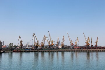 Fototapeta premium Panoramic view of industrial sea port with multiple cargo cranes