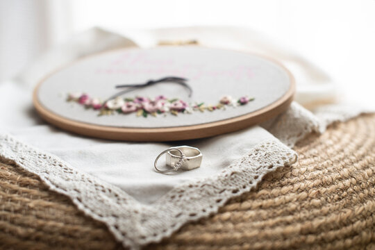 Close-up of two wedding rings and an embroidery hoop