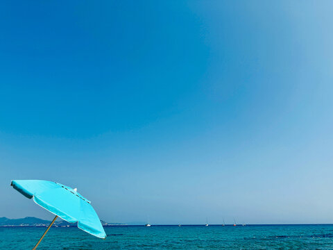 Turquoise parasol on a beach in summer, La Ciotat, Bouches-du-Rhone, Provence-Alpes-Cote d'Azur, France