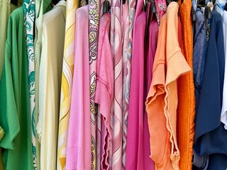 Full frame close-up of assorted colourful women's clothes hanging on a clothes rail