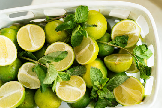 Overhead view of lemons and mint leaves in a plastic basket