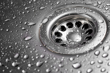 Clean stainless steel sink drain with fresh water droplets