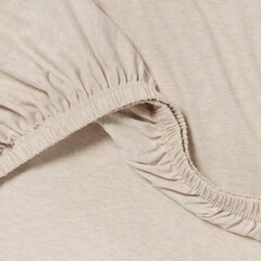 Soft beige fabric with gathered elastic edge for comfortable clothing design and fashion applications.