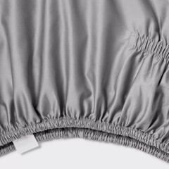 Soft gray fabric with elastic edge shows texture and sheen in a close-up view, revealing its detailed material quality and design features.