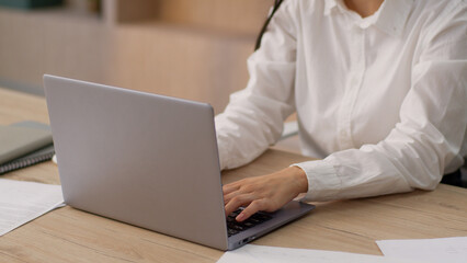 Concentrated focused Asian Korean business woman female professional CEO leader boss Japanese Chinese businesswoman girl office worker working online laptop pc desktop computer typing report indoors