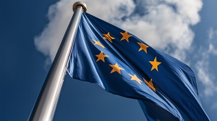 European Union flag fluttering proudly against a clear blue sky with clouds during a sunny day