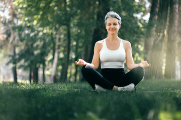Mature Woman in Sukhasana Yoga Pose Meditating in Forest for Peaceful Outdoor Mindfulness