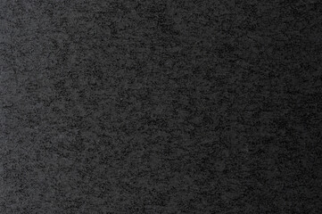 Dark textured surface with subtle variations in tone creating interesting patterns