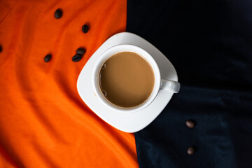 Ceramic coffee cup with scattered coffee beans