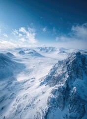 Fototapeta premium High-angle, winter mountain range. Snow-covered peaks and valleys under a vibrant blue sky