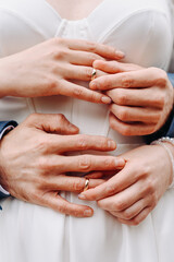 bride and groom hands putting on rings
