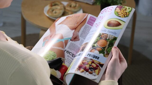 Woman reading lifestyle magazine indoors, closeup view