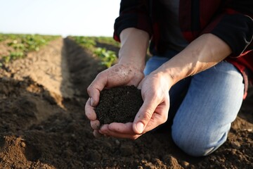 Man holding pile of soil in field, closeup