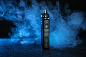 Electronic smoking device on black table in blue light