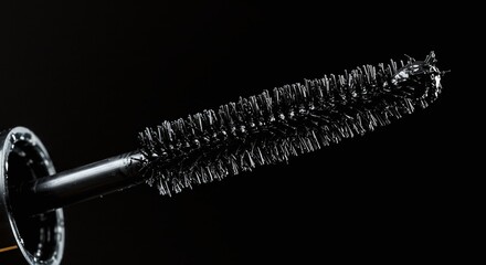 Black Makeup Mascara Wand with Brush in Close Up on Dark Background