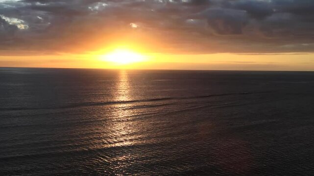 Colourful scenic sunset with sun setting by Pacific ocean horizon off Tokoriki island Fiji.
