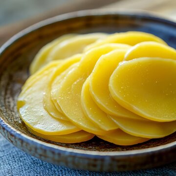 closeup of tsukemono pickled daikon slices on ceramic plate vibrant yellow color macro Japanese pickle photography