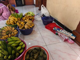 A basket of fruit for sale, prepared with cling wrap to be packaged for sale, Bananas of varied...