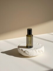A small green glass bottle with a black cap on a white stone against a neutral colored background