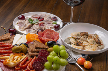 Traditional meal with dumplings and assorted cured meats on rustic table
