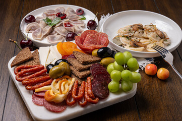 Traditional meal with dumplings and assorted cured meats on rustic table