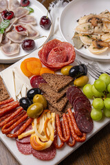 Traditional meal with dumplings and assorted cured meats on rustic table