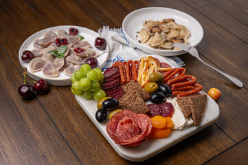 Traditional meal with dumplings and assorted cured meats on rustic table