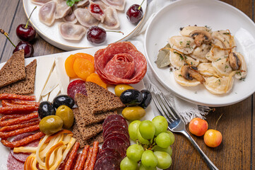 Traditional meal with dumplings and assorted cured meats on rustic table