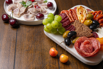 Traditional meal with dumplings and assorted cured meats on rustic table